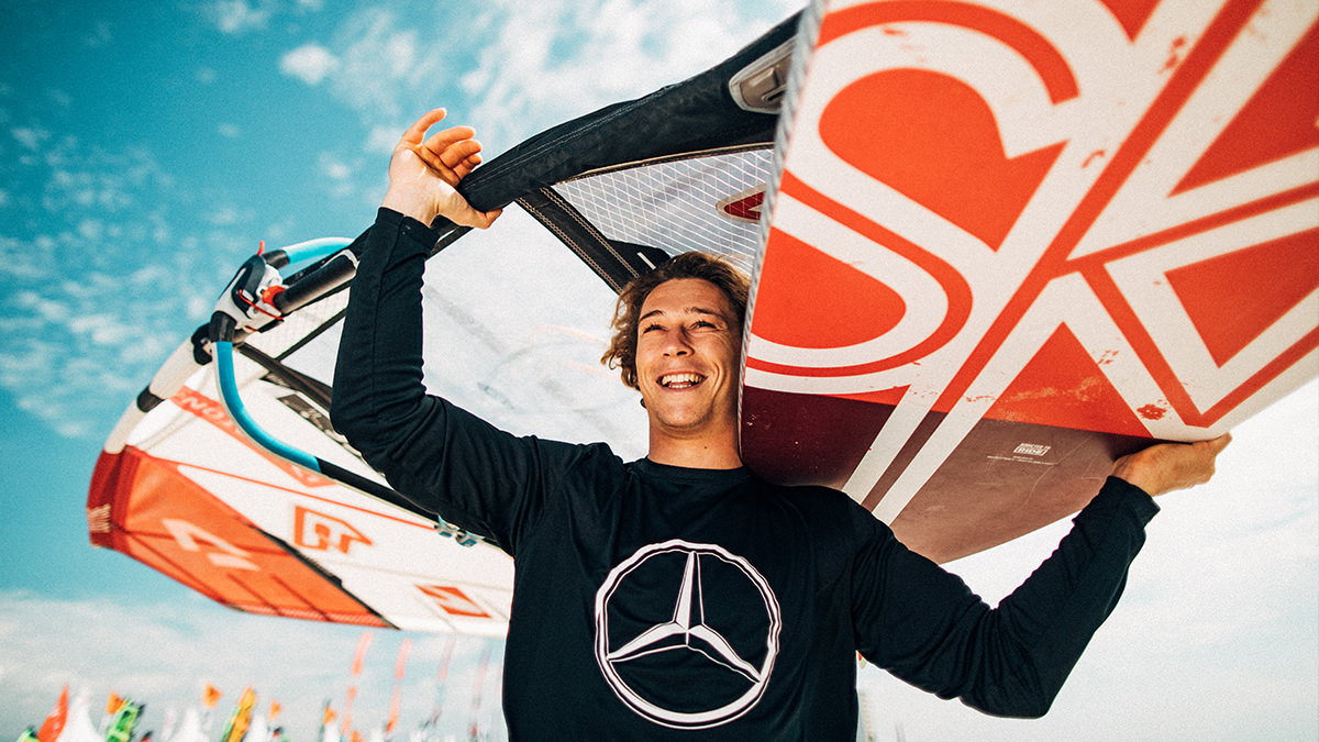 Mann mit Surfbrett auf der Schulter