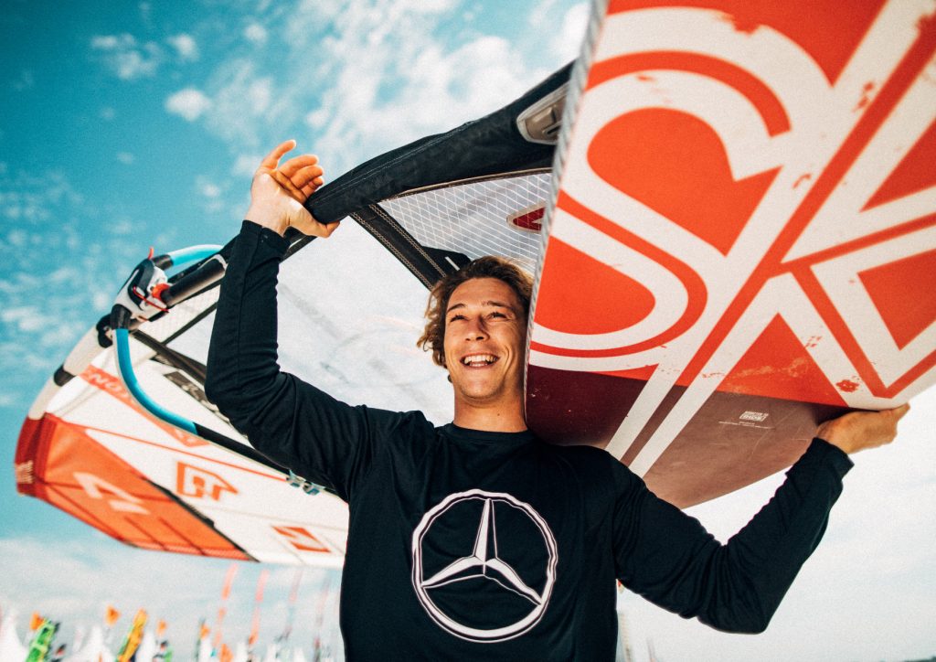 Mann mit Surfbrett auf der Schulter