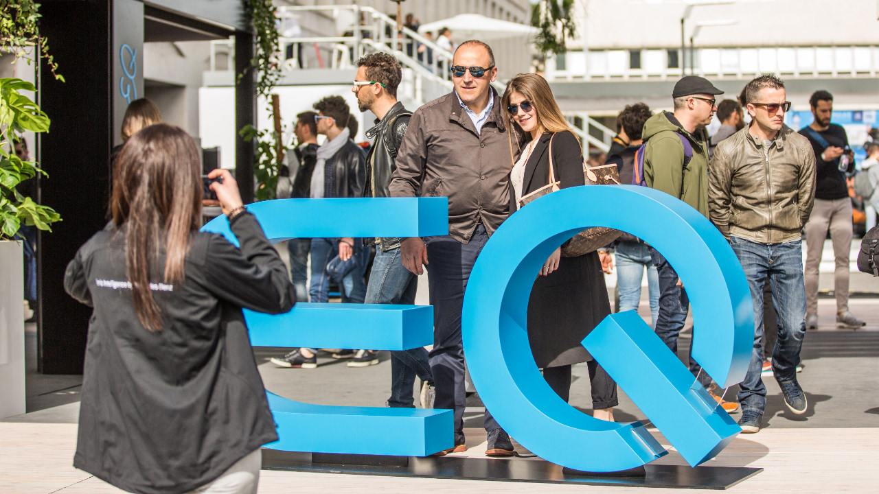 Menschen posieren vor EQ Aufsteller