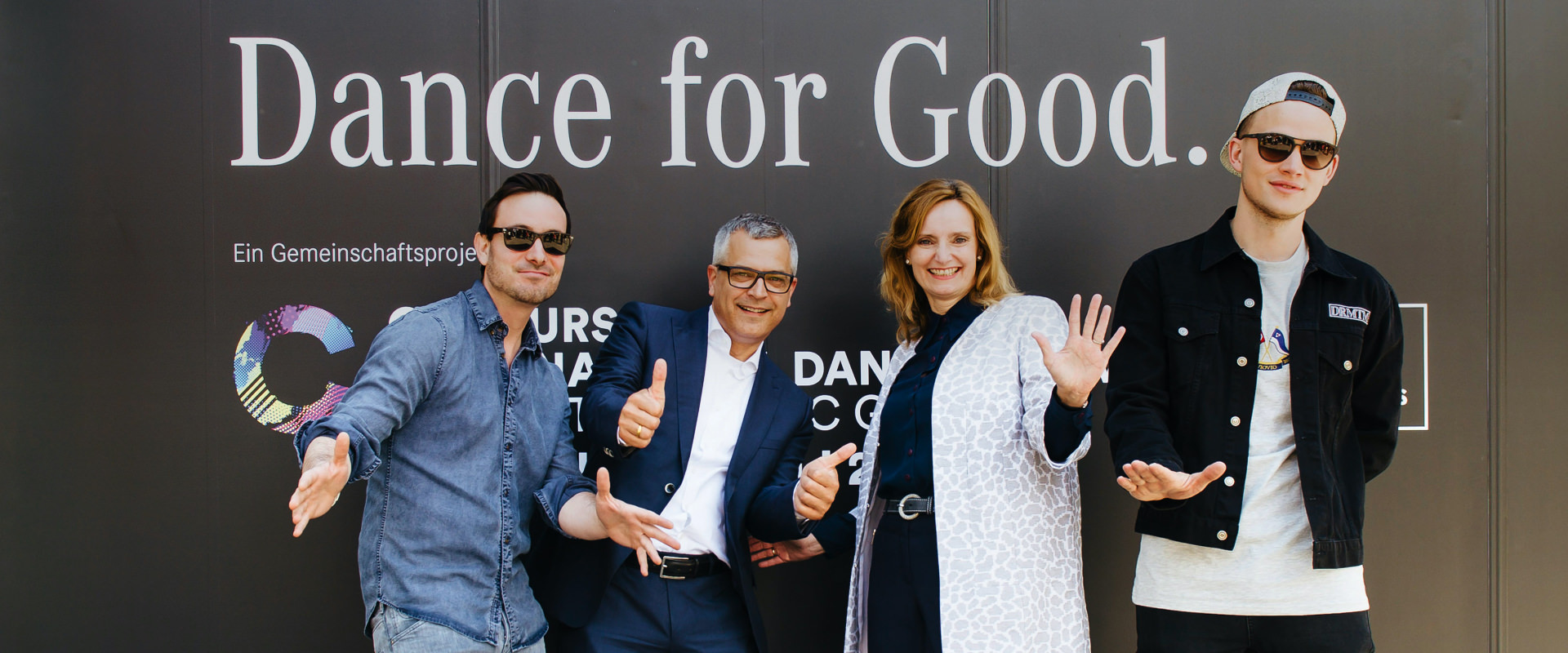 Menschen vor Dance for Good Schriftzug